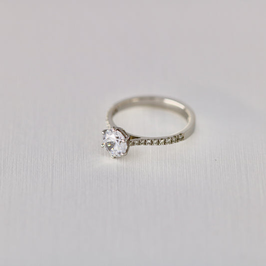 Six claw solitaire with diamonds in band
